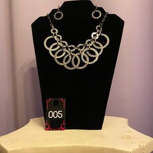 It is all in the details! This short hanging necklace with matching earrings pop